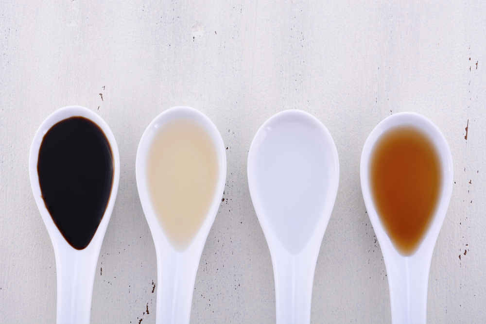 Vinegars on white spoons: Balsamic AppleCider White Malt